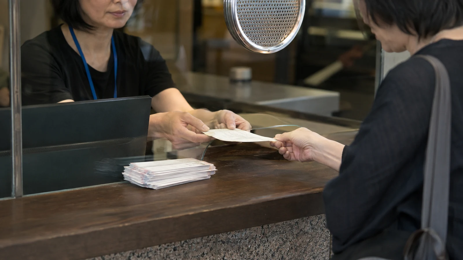 会場のチケット窓口で来場者の券を確認する係員。