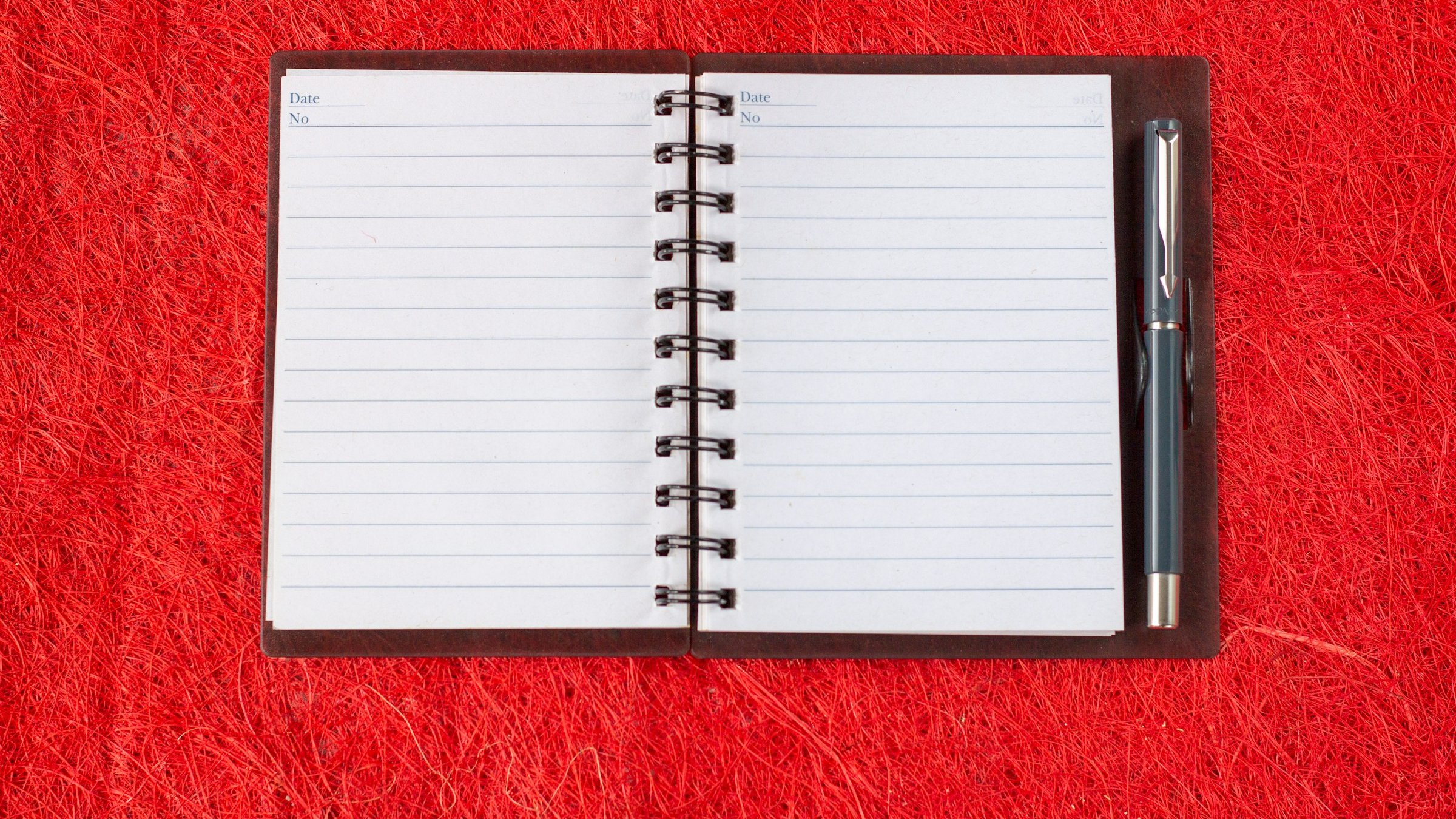フラットレイで配置されたブルーのノートと黒ペン。RFP・提案書・スコープ定義書・契約書の書面事前確認を象徴する物撮り。