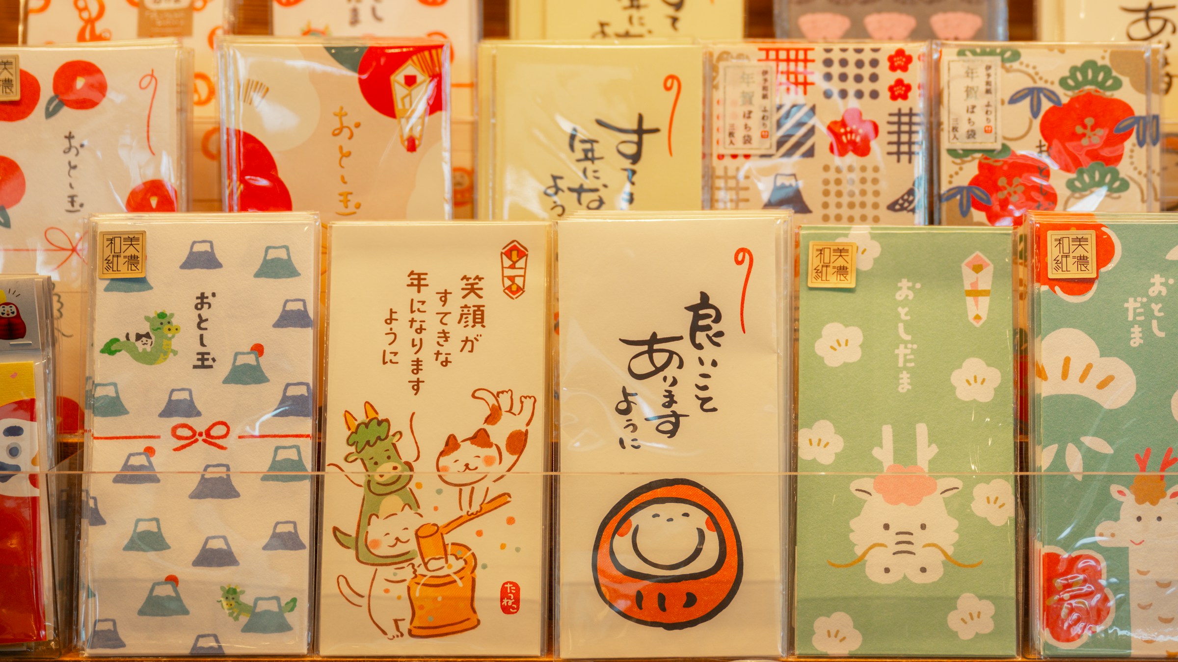 日本のおとし玉袋(笑顔がすてきな年に、良いことがあぃように)の店頭陳列。達磨・富士山・梅のイラスト入り和柄デザイン。