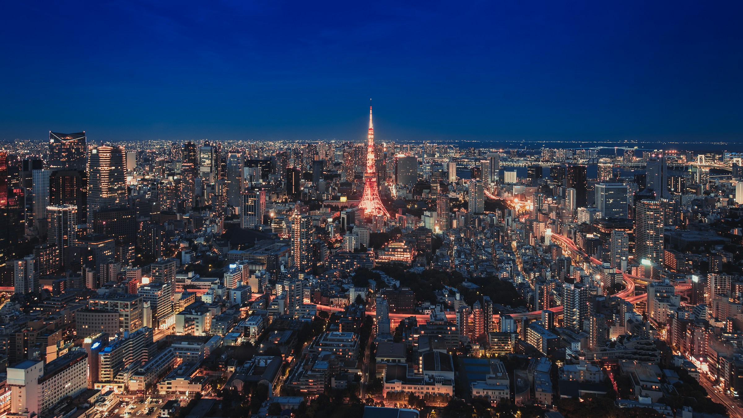 夜の東京。中央に東京タワーが灯る都市の俯瞰。