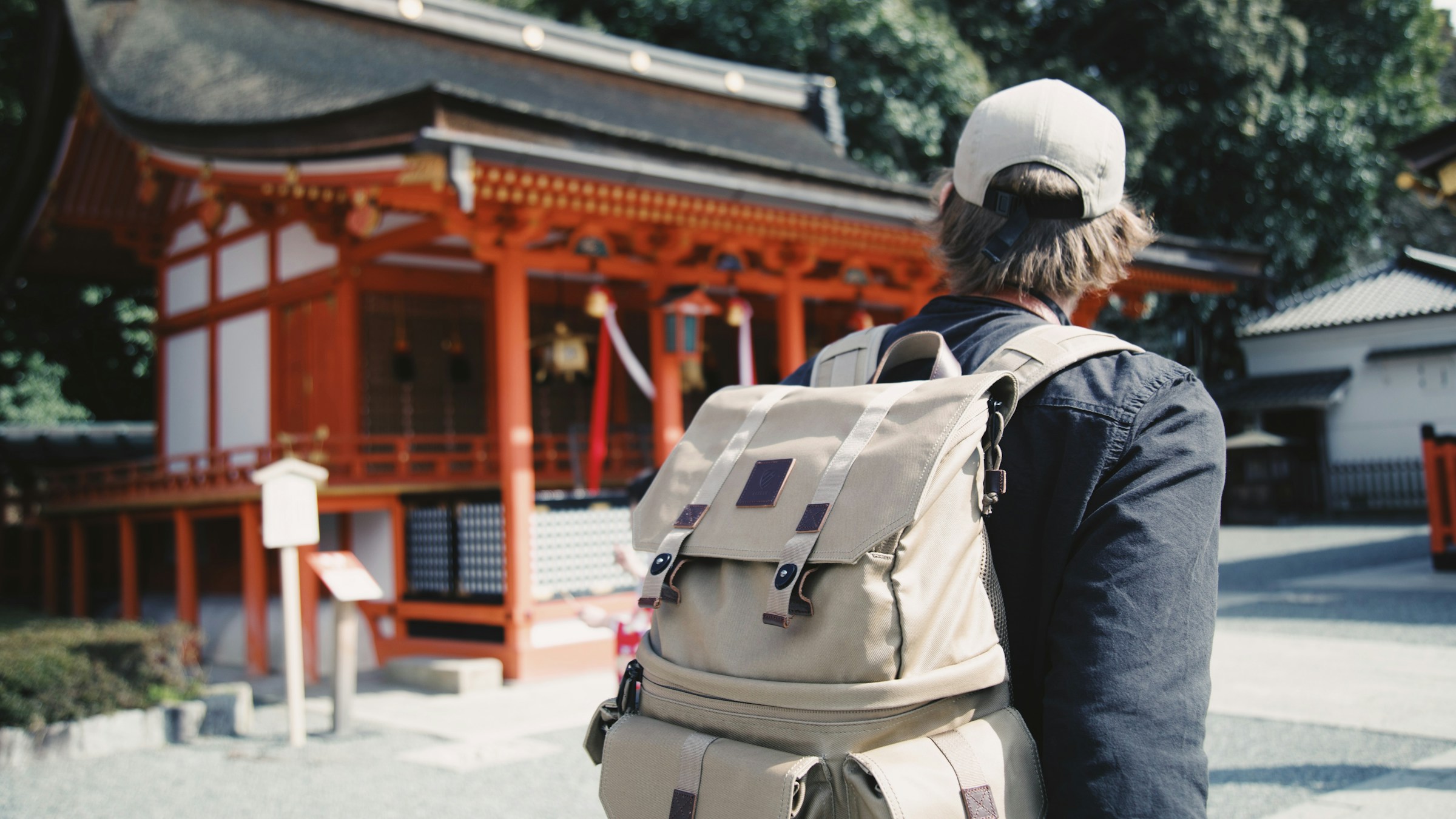 バックパックを背負った旅行者と日本のお寺。